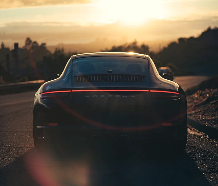 Rear view of Porsche with sunset