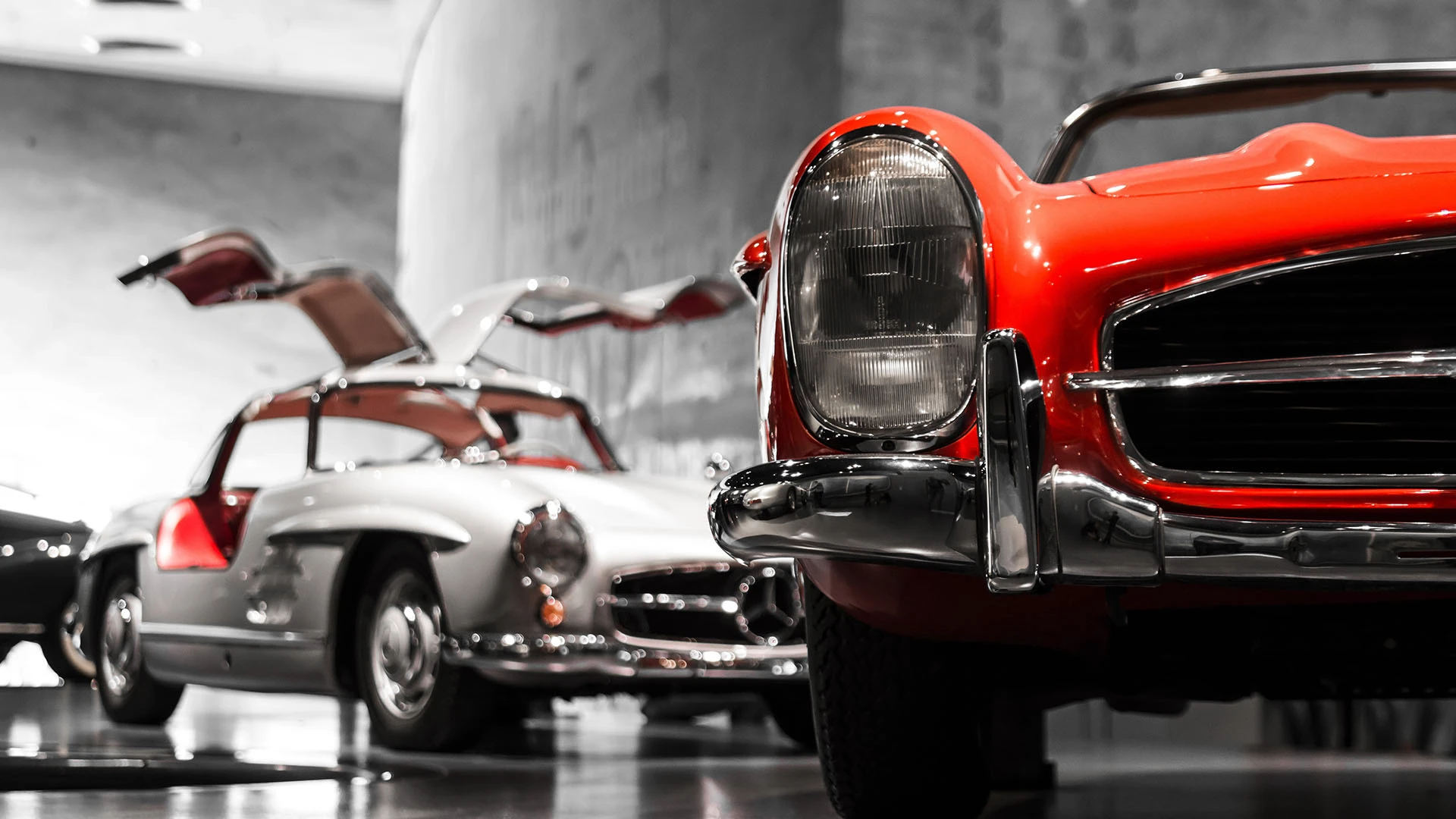 Silver and Read Mercedes 300L Gullwing classic cars in showroom