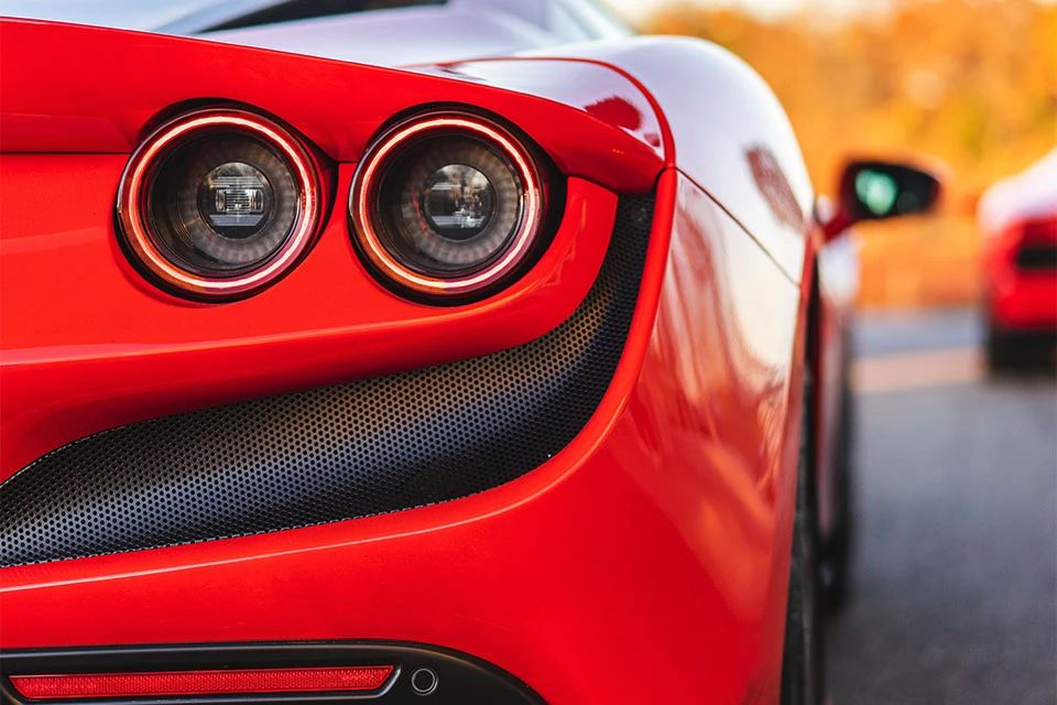 Close-up image of the rear lights of a red Ferrari