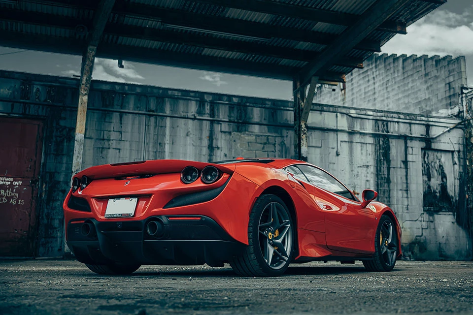 Image of the rear of a red Ferrari in an industrial setting