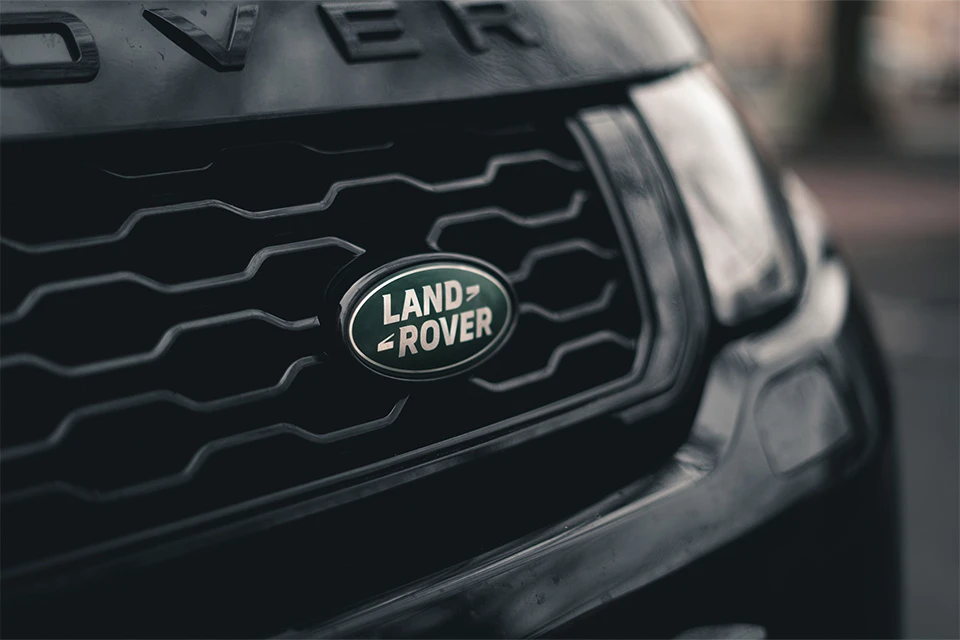 Front of black Land Rover including the green Land Rover logo